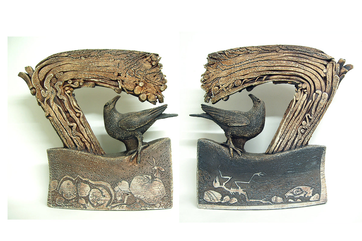 Ceramic sculpture of bird under a tree