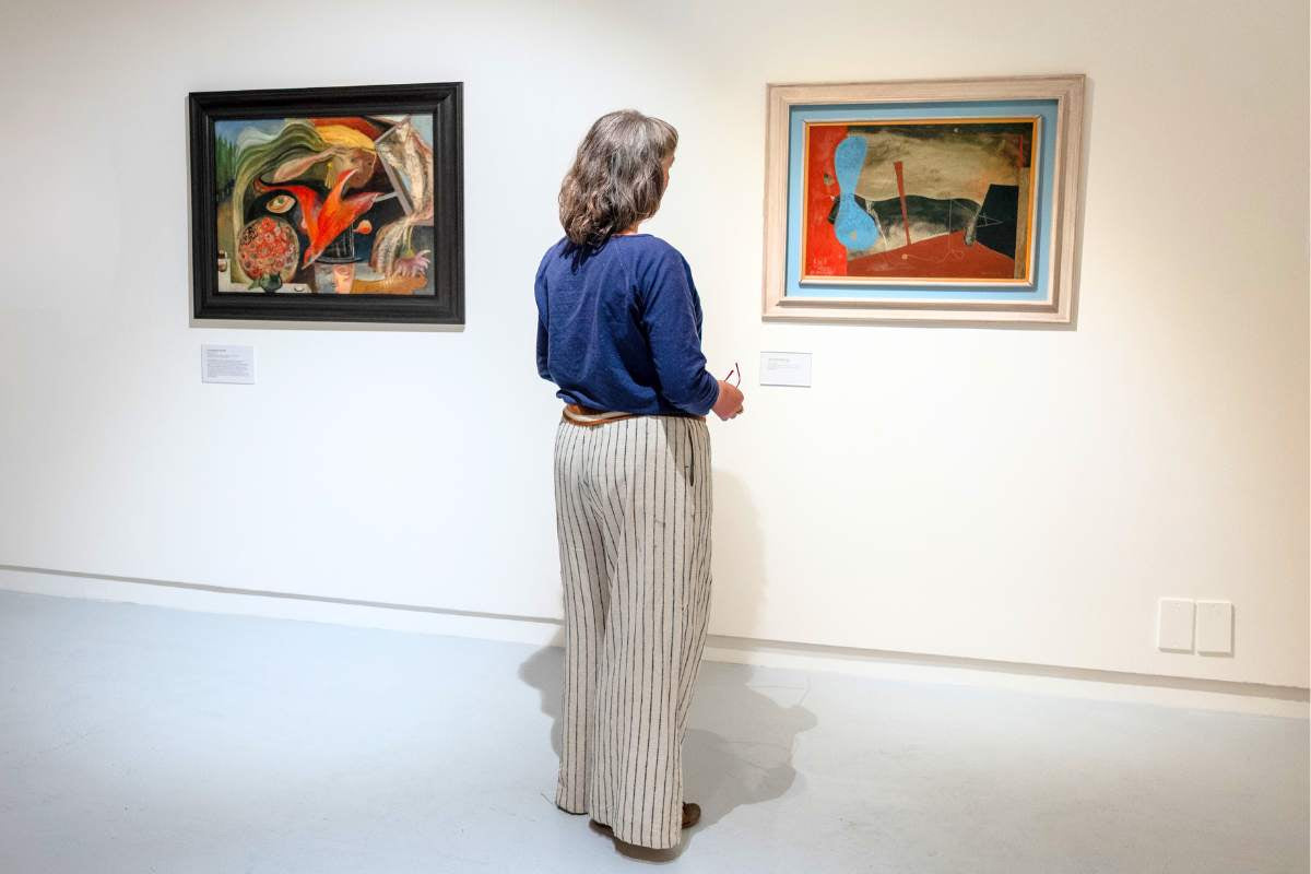 Into Abstraction, image by Jim Wileman. Woman looking at paintings in gallery.
