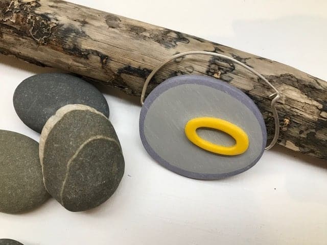 Large Yellow and Grey Fibula Brooch by Bronwen Gwillim with pebbles and piece of driftwood