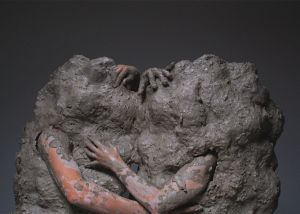 Image shows two people covered in clay