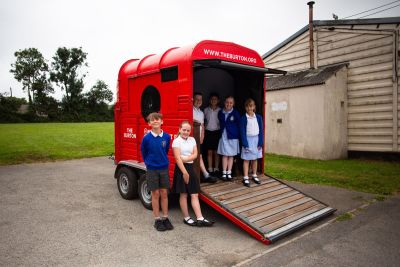 Image shows children from a rural school standing outside The Burton Art Box