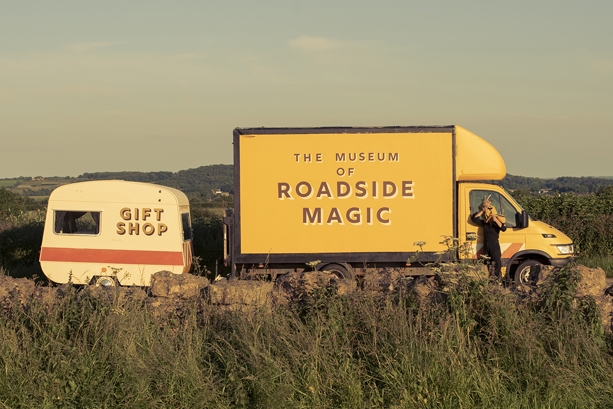 Image shows yellow van followed by small caravan