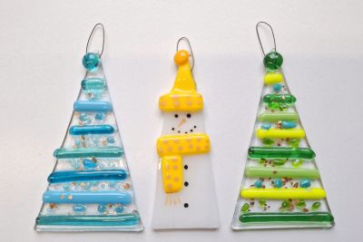 Image shows fused glass christmas decorations in the shape of a christmas trees and snowman