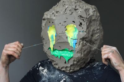 Will.je.suis (2020) by William Cobbing, showing a man with a clay head and yellow/green eyes and mouth
