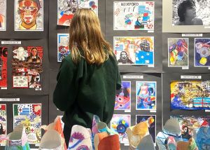 Image of a girl at the Schools Exhibition 2025, looking at artwork on the walls